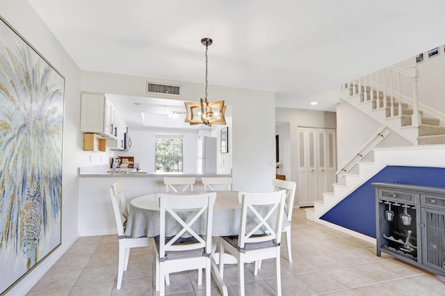 dining area with light tile patterned floors and a notable chandelier