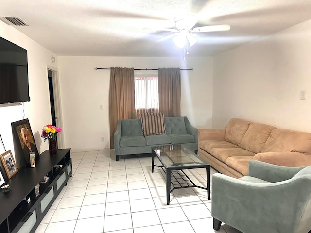 living room featuring ceiling fan, light tile patterned flooring, and a textured ceiling