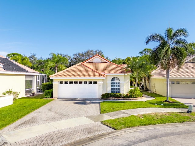 mediterranean / spanish house with a garage and a front lawn