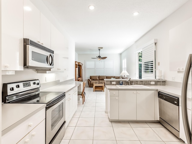 kitchen with kitchen peninsula, white cabinetry, ceiling fan, and appliances with stainless steel finishes