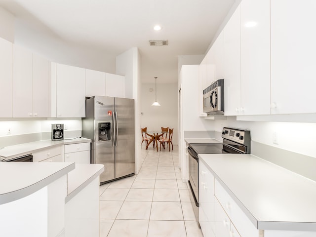 kitchen featuring white cabinets, appliances with stainless steel finishes, decorative light fixtures, and light tile patterned floors