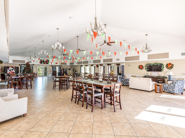 tiled dining area with ceiling fan and high vaulted ceiling