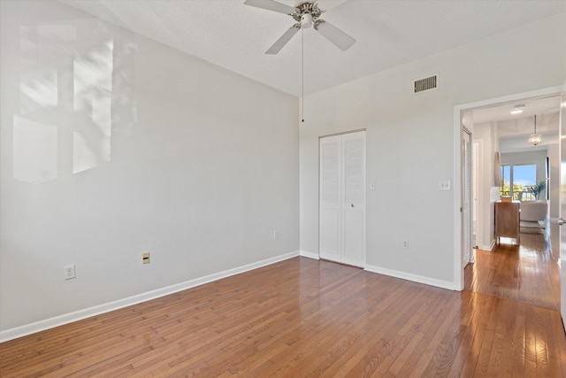 empty room with ceiling fan, dark hardwood / wood-style flooring, and a textured ceiling