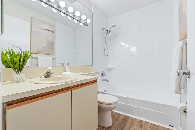 full bathroom with vanity, tiled shower / bath combo, hardwood / wood-style flooring, and toilet