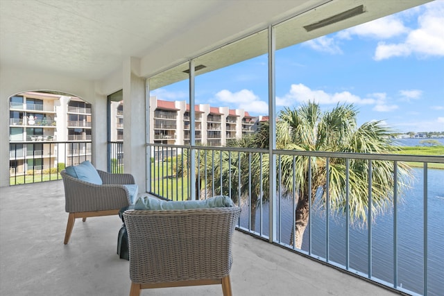 sunroom / solarium featuring a water view