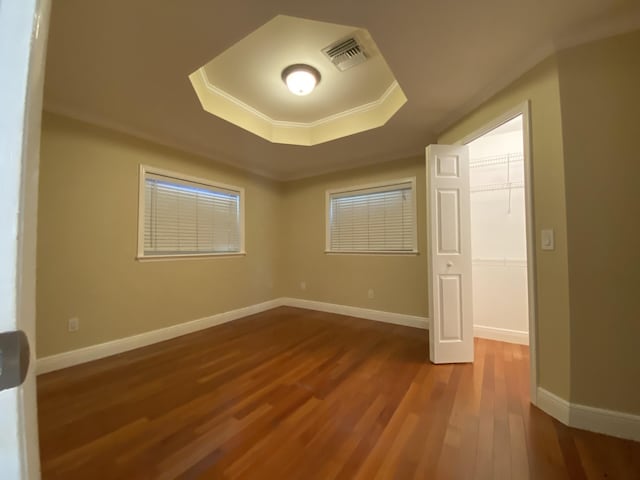 empty room featuring a tray ceiling and hardwood / wood-style flooring