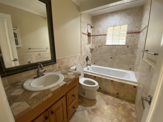 full bathroom featuring tiled shower / bath combo, toilet, and vanity