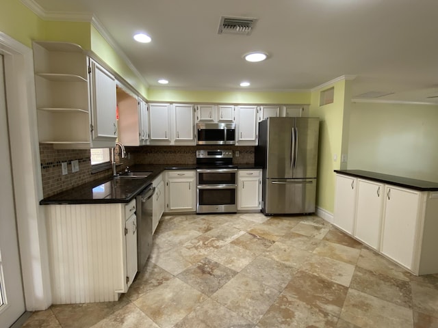 kitchen featuring stainless steel appliances, white cabinetry, tasteful backsplash, and sink