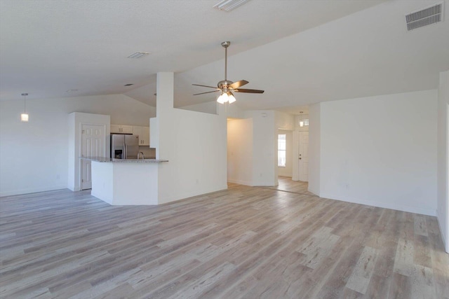 unfurnished living room with light wood-type flooring, vaulted ceiling, and ceiling fan