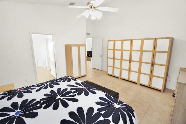 bedroom featuring light tile patterned floors, visible vents, and a towering ceiling