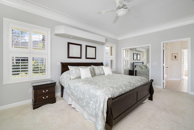 bedroom featuring ceiling fan, a closet, light carpet, and ornamental molding