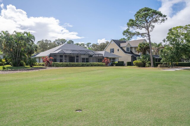 view of front of house with glass enclosure and a front yard