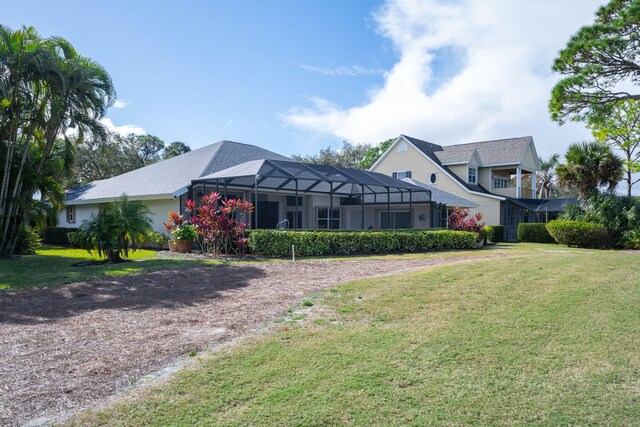 view of front of house featuring a front yard and glass enclosure