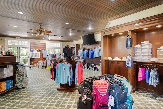 misc room with carpet floors, wooden walls, ceiling fan, ornamental molding, and wood ceiling