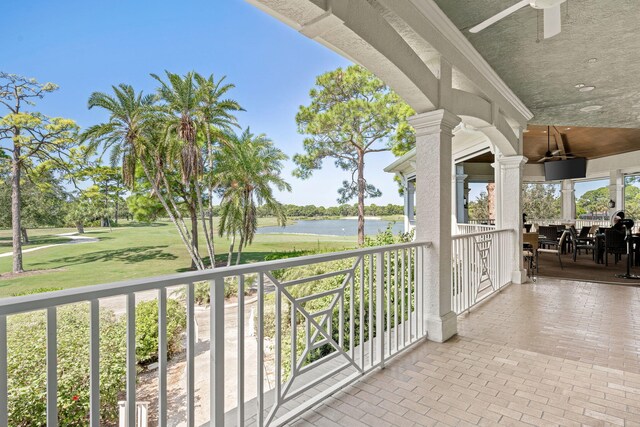 balcony with ceiling fan and a water view