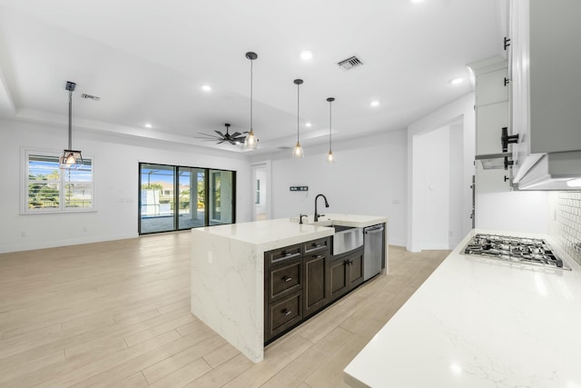 kitchen featuring ceiling fan, sink, stainless steel appliances, and decorative light fixtures