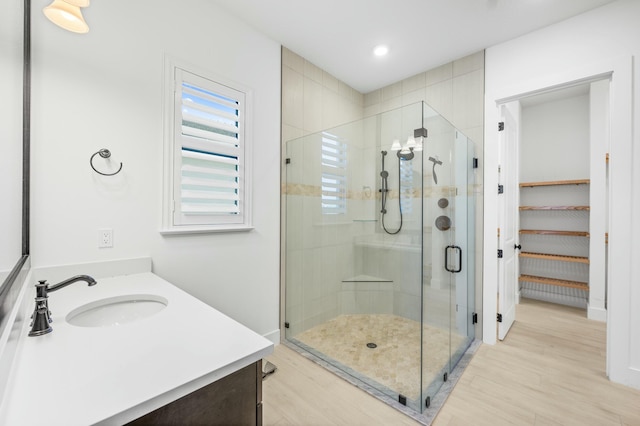 bathroom with vanity, hardwood / wood-style flooring, and walk in shower