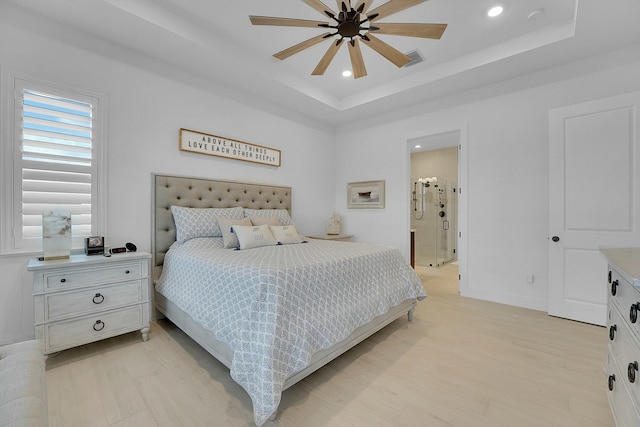 bedroom featuring ceiling fan, a raised ceiling, and light hardwood / wood-style floors