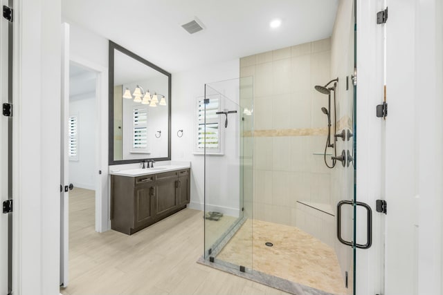 bathroom featuring hardwood / wood-style flooring, vanity, and walk in shower