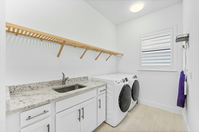 washroom featuring cabinets, independent washer and dryer, light hardwood / wood-style flooring, and sink