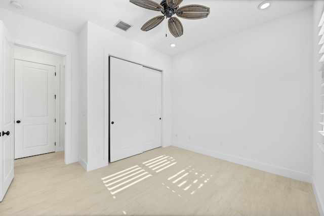 unfurnished bedroom featuring ceiling fan, a closet, and light hardwood / wood-style floors