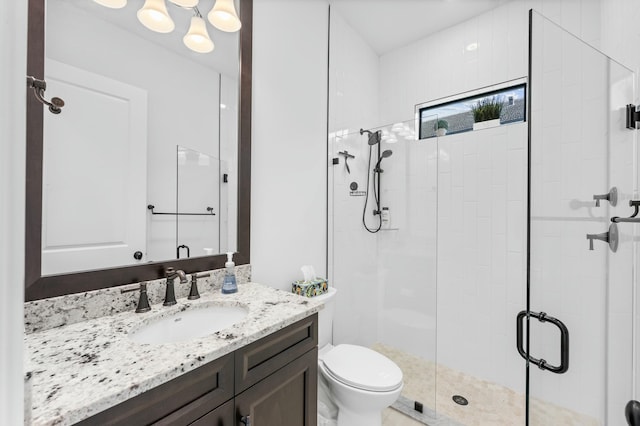 bathroom with a shower with door, vanity, and toilet