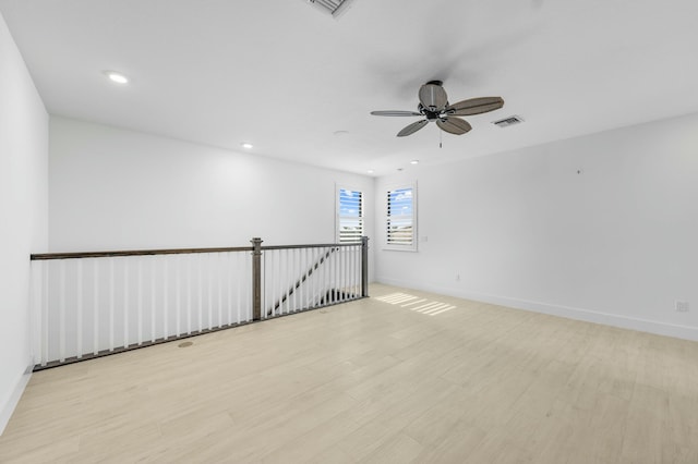 spare room with ceiling fan and light wood-type flooring