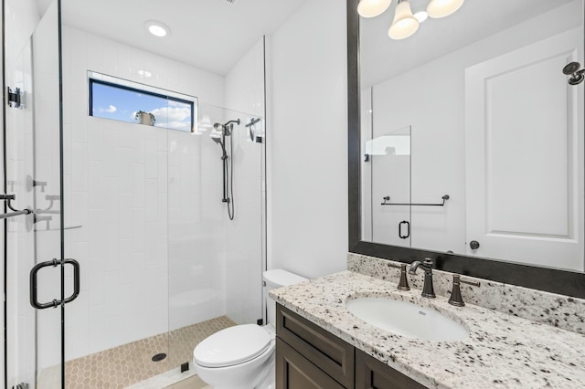 bathroom with vanity, an enclosed shower, and toilet