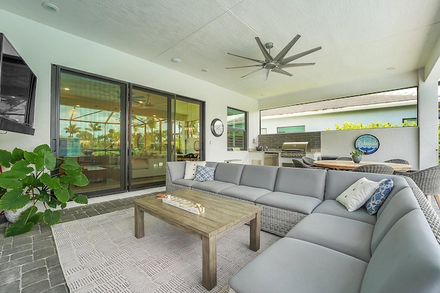 living room featuring ceiling fan and a textured ceiling