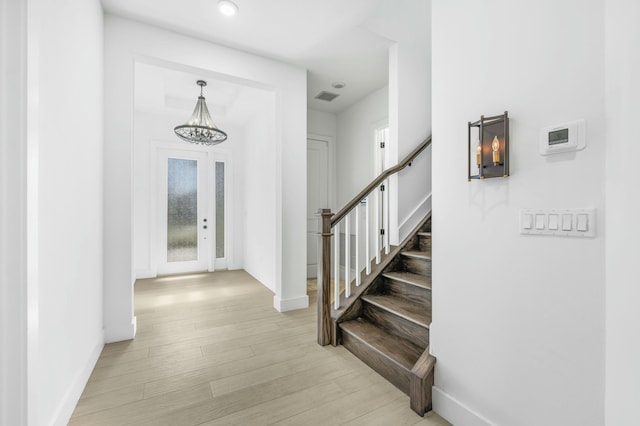 entryway featuring a chandelier and light hardwood / wood-style floors