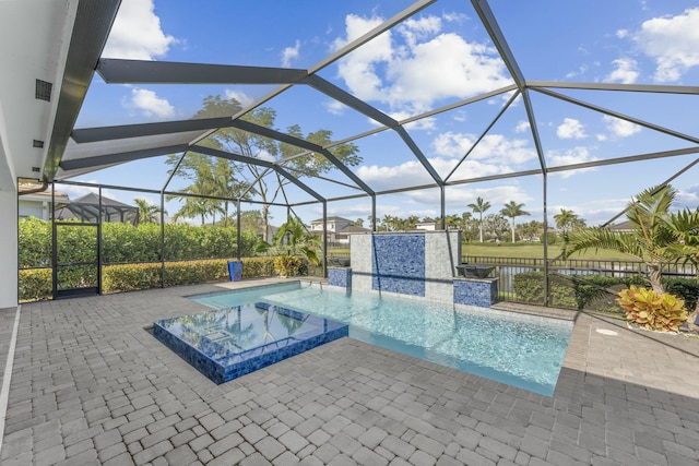 view of pool featuring glass enclosure, an in ground hot tub, and a patio