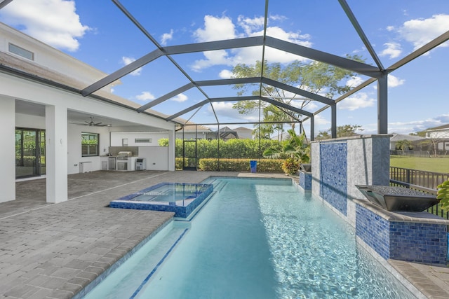 view of swimming pool with an in ground hot tub, an outdoor kitchen, a patio area, and a lanai