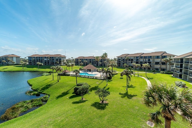 surrounding community featuring a water view and a lawn