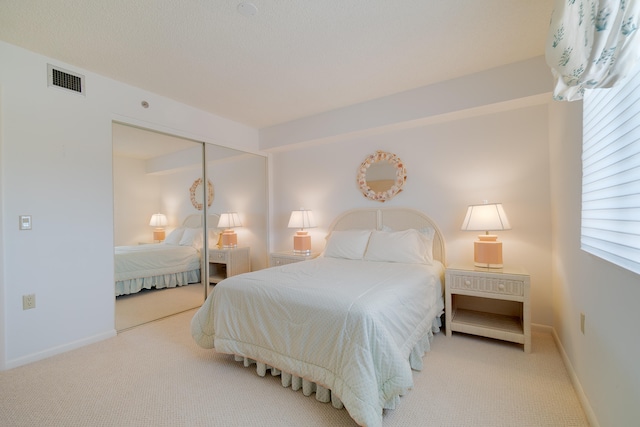 bedroom featuring light carpet and a closet