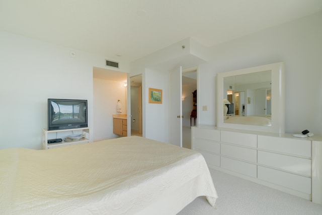 bedroom featuring carpet flooring and connected bathroom