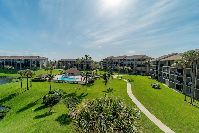 view of home's community with a pool and a lawn