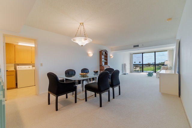 carpeted dining room featuring washer / dryer