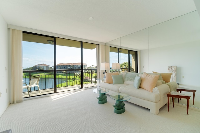 carpeted living room featuring a water view and a wall of windows