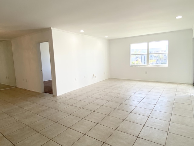 empty room featuring light tile patterned floors and ornamental molding