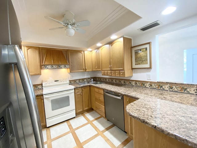 kitchen featuring appliances with stainless steel finishes, premium range hood, ceiling fan, sink, and stone counters