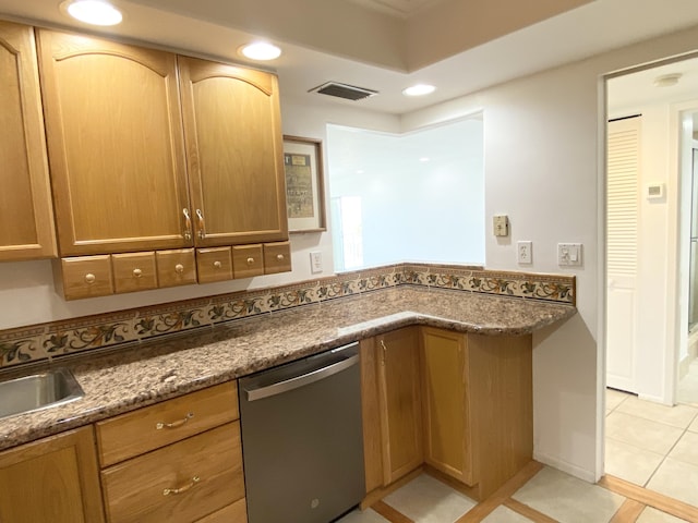 kitchen featuring dishwasher, sink, dark stone countertops, and light tile patterned flooring