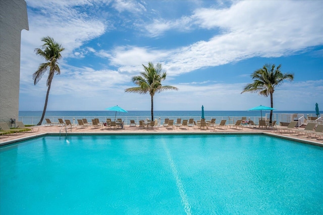 view of pool with a patio and a water view