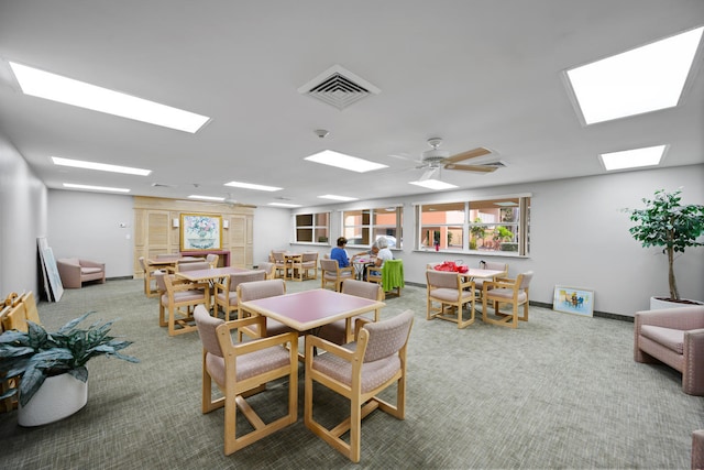 carpeted dining area with ceiling fan