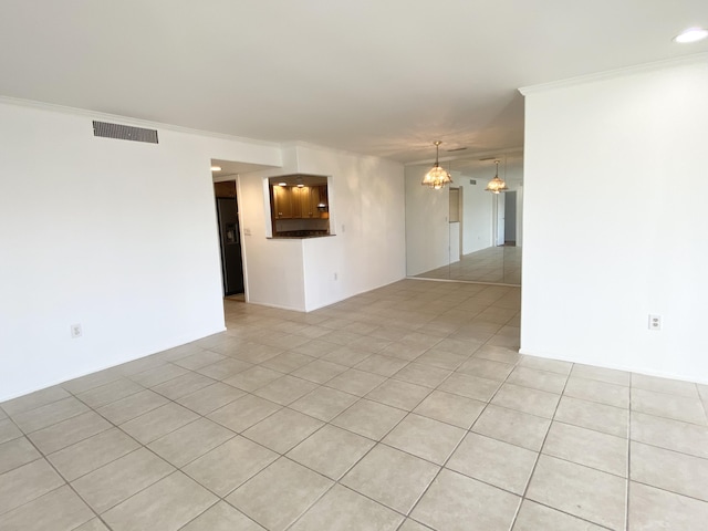 tiled spare room with a notable chandelier and crown molding