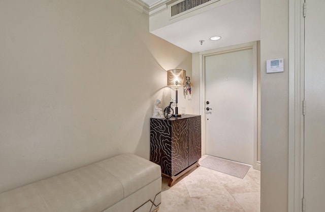 interior space featuring crown molding and light tile patterned floors