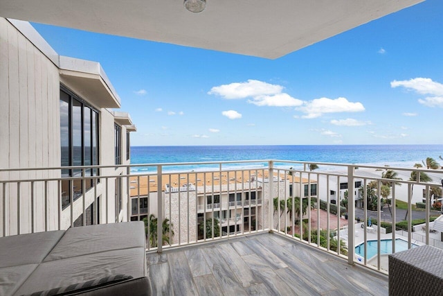 balcony featuring a view of the beach and a water view