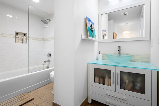 full bathroom with vanity, toilet, and tiled shower / bath