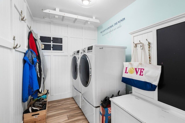 washroom with light wood-type flooring and washing machine and dryer