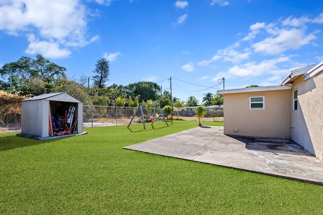 view of yard featuring a playground, a patio area, and a storage shed