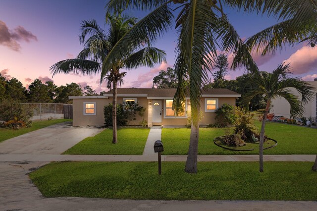 single story home featuring a lawn